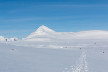 Fototapeta na wymiar Snow-covered mountain with blue skies