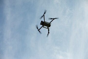 Drone in sky. Quadro copter flies in air. Surveillance from height. Four propellers.