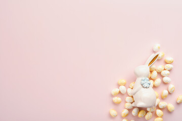 Happy Easter. Easter eggs and white rabbit decoration isolated on trendy pastel pink background with white and yellow roses. Spring Happy Easter holiday card and mock up background. Top view flat lay.