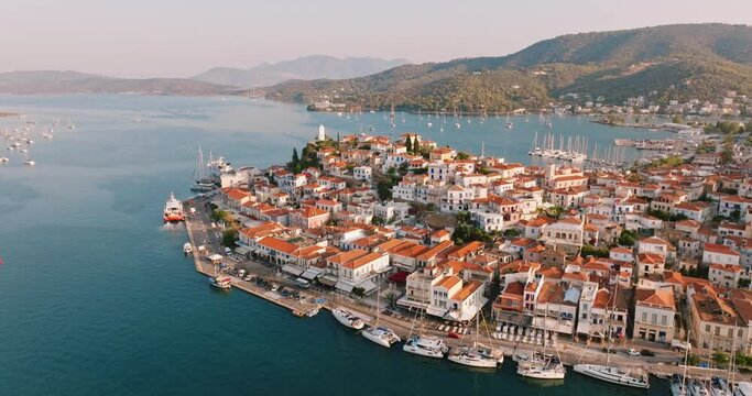 Poros island, Greece. Sailing yacht in marina at Aegean sea Aerial view of drone slide on beautiful panorama of golden sinrise sailing yachts high mountains of sea harbors summer. Travel. Tourism