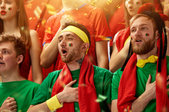 Sport fans emotionally cheering up favourite football, soccer team of portugal at stadium during game, singing anthem. Concept of sport, competition, championship, emotions, hobby and entertainment - Powered by Adobe