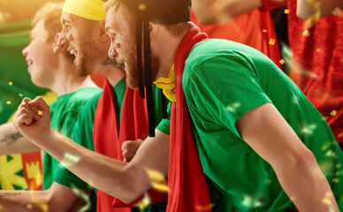 Portugal football fans supporting, watching match, emotionally cheering up favourite football, soccer team at stadium during game. Concept of sport, competition, championship, emotions, entertainment