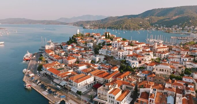Poros island, Greece. Sailing yacht in marina at Aegean sea Aerial view of drone slide on beautiful panorama of golden sinrise sailing yachts high mountains of sea harbors summer. Travel. Tourism