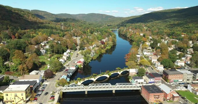 The Bridge of Flowers spans the Deerfield River with the rolling hills of Western Massachusetts as a backdrop in Shelburne Falls, MA during fall.
