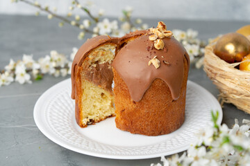 Cut Easter cake on plate decorated with spring flower branches