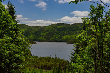 Fototapeta na wymiar Landscape with lake, trees and hills, Acropole des Draveurs, Quebec, Canada, beautiful sky with clouds