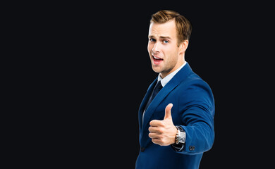 Photo of excited businessman showing thumbs up like hand sign gesture, in blue confident suit,...