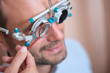 Confident man is receiving qualified eye care in the optician center