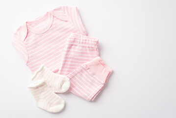 Baby shower concept. Top view photo of pink infant clothes shirt pants and socks on isolated white background
