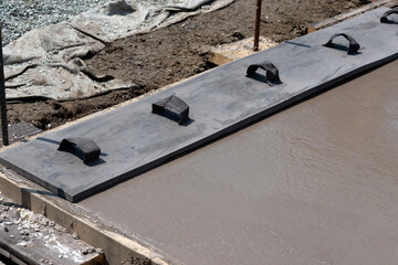 Workers pouring concrete for a stamped floor