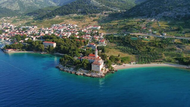 Aerial view of Bol town with pebble beaches and Dominician monastery in Adriatic sea on Brac island, Croatia. 4k drone video. Summer vacation resort