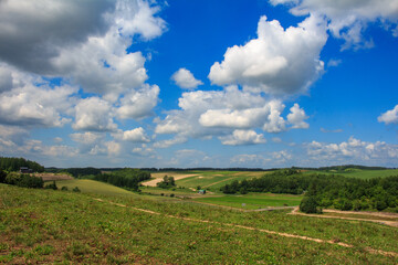 丘が広がる田園風景と青空と白い雲