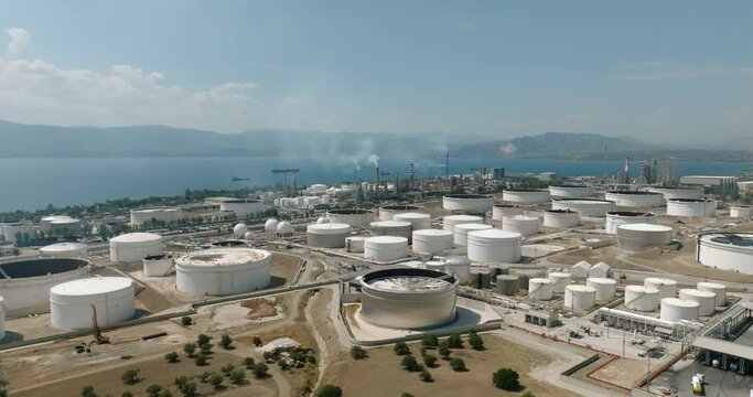 Vast territory of large factory round tanks for production of industrial fuel oil on sunny summer day from Aerial view Corinth Canal in Greece  