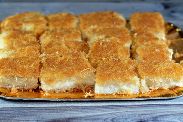 A traditional middle eastern dessert Knafeh Konafa made with spun pastry kataifi, soaked in a sweet...