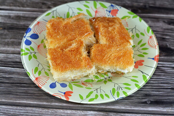 A traditional middle eastern dessert Knafeh Konafa made with spun pastry kataifi, soaked in a sweet...