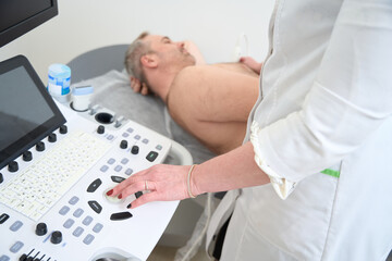 Obraz na płótnie Canvas Doctor using ultrasound machine to scan of a senior male patient