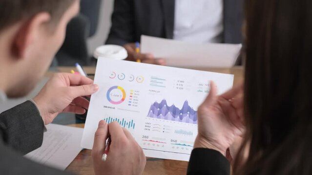 A conference room where executives and marketers are looking at sales documents to analyze, plan marketing and do sales promotions, they are brainstorming. Sales management concept.