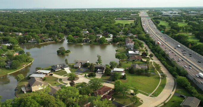 Aerial view of a neighborhood with lake and proximity to a highway.