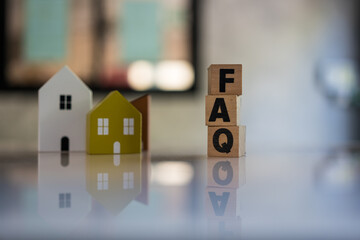 Cubes with message FAQ with wooden home. Quesiton and answer about housing problems