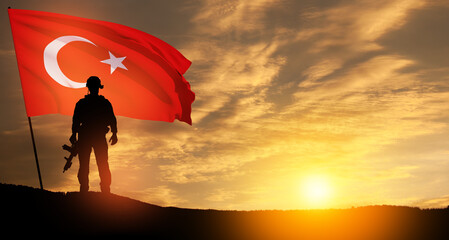 Silhouette of soldier with Turkey flag on background of sunset.