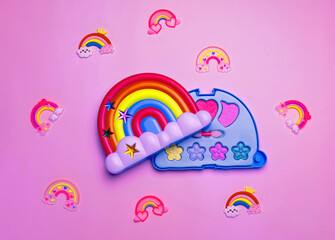 Children's set of decorative cosmetics for a little girl in the shape of a rainbow. Flat lay.