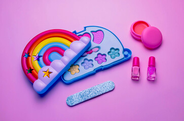 Children's set of decorative cosmetics for a little girl in the shape of a rainbow. Flat lay.