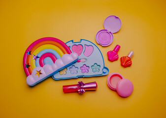 Children's set of decorative cosmetics for a little girl in the shape of a rainbow. Flat lay.