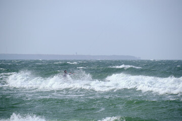 Kitesurfing in the sea during a storm and big waves.