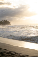 person swimming into ocean on a surf board