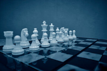 White chess pieces chessboard with blue background.