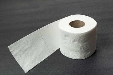 Roll of toilet paper on gray background. White soft hygienic paper. Restroom soft touch toilet paper.