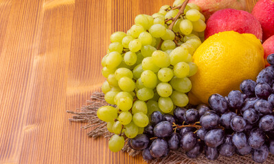 Different grapes and apples on a wooden background. Healthy food.