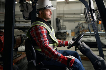 Man sitting in loading truck and working at enterprise