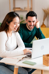 Obraz premium Happy couple working on laptop and making notes