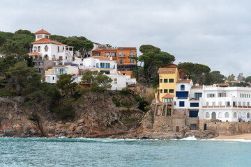 Old and modern residential buildings on the Costa Brava. Holiday homes on the rocky sea coast.