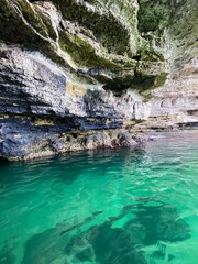 Rocky grotto with turquoise clear water, beautiful nature photo.