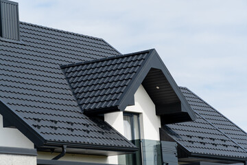 The roof of a modern new house. Tiled covering of building. Modern European house - obrazy, fototapety, plakaty