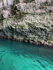 Rocky grotto with turquoise clear water, beautiful nature photo.