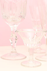 Crystal glasses in front of pink background. Minimal vintage composition.