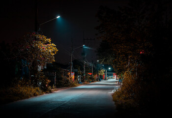 empty asphalt road at night with street lamps	