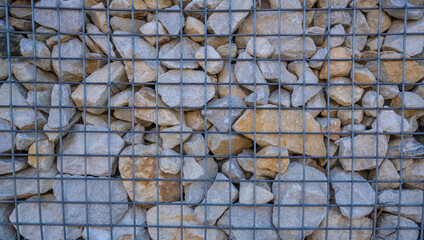 The stones for strengthening the wall are covered with a metal mesh.