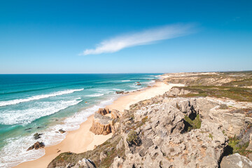 Rocks surround the sandy beach of Praia do Malhao Sul on the Atlantic coast near Vila Nova de...