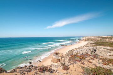 Rocks surround the sandy beach of Praia do Malhao Sul on the Atlantic coast near Vila Nova de Milfontes, Odemira, Portugal. In the footsteps of Rota Vicentina. Fisherman trail