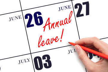 Hand writing the text ANNUAL LEAVE and drawing the sun on the calendar date June 26
