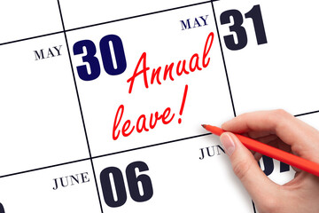 Hand writing the text ANNUAL LEAVE and drawing the sun on the calendar date May 30
