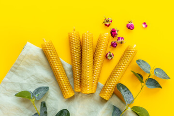 Honey aroma beeswax candles with leaves, top view. Eco home decor product