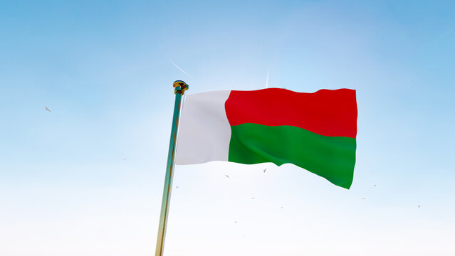 Flag of Madagascar flag waving in the wind, sky and sun background. Madagascar Flag.