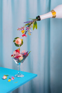 Champagne bottle with flowers and leaves. Minimal concept Art direction with spring and party theme.