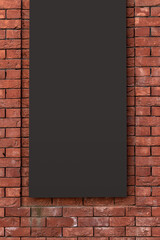 Dark empty billboard on a red brick wall.