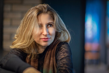 Portrait of a young beautiful fair-haired girl in the studio under artificial lighting.